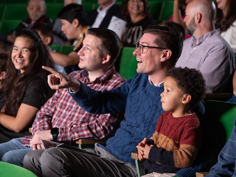 Family in green auditorium seats